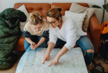 Multi-generational family gathered around table looking at travel brochures and maps while planning their vacation