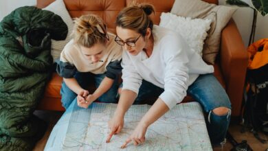 Multi-generational family gathered around table looking at travel brochures and maps while planning their vacation
