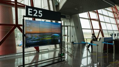 Modern airport boarding gate with electronic displays and passenger queuing area