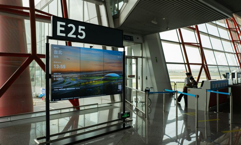 Modern airport boarding gate with electronic displays and passenger queuing area