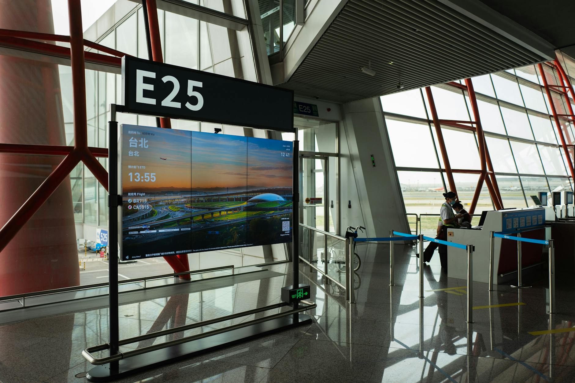 Modern airport boarding gate with electronic displays and passenger queuing area