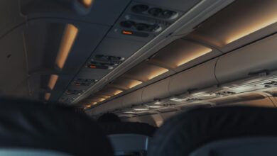 Modern aircraft cabin interior with passenger seats and overhead controls