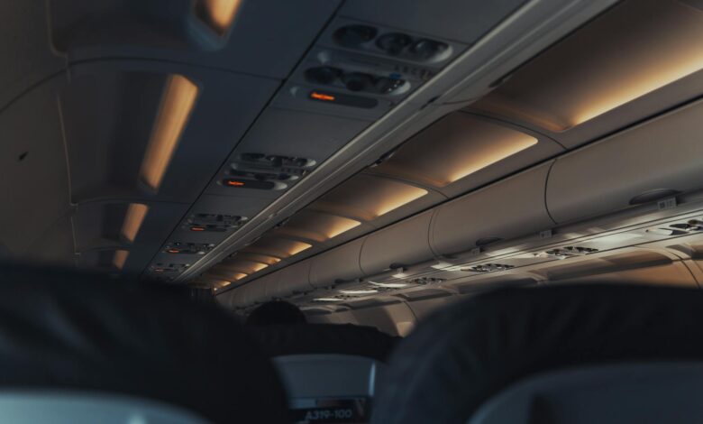 Modern aircraft cabin interior with passenger seats and overhead controls