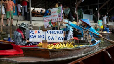 Traditional wooden boats at Vietnamese floating market with vendors selling fresh produce