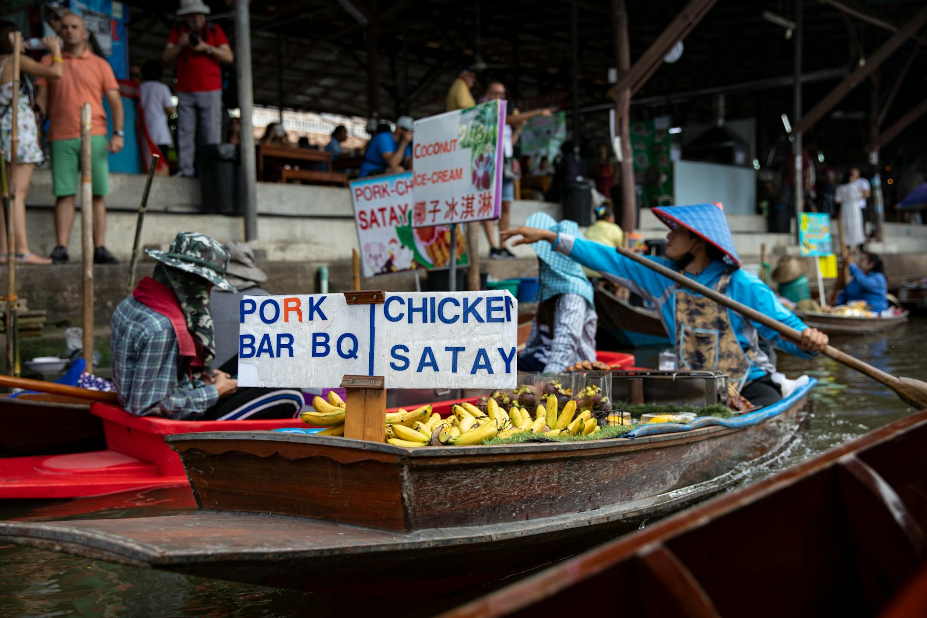 Traditional wooden boats at Vietnamese floating market with vendors selling fresh produce