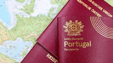 Open passport with travel documents and visa application papers on desk