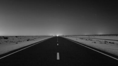 Starry night sky over desert landscape with mountains silhouetted against the Milky Way