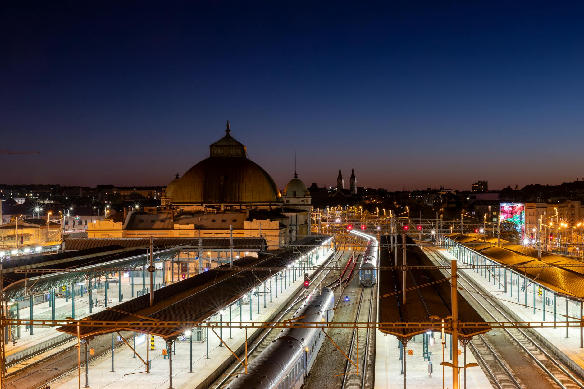 Modern train station platform at night with high-speed train