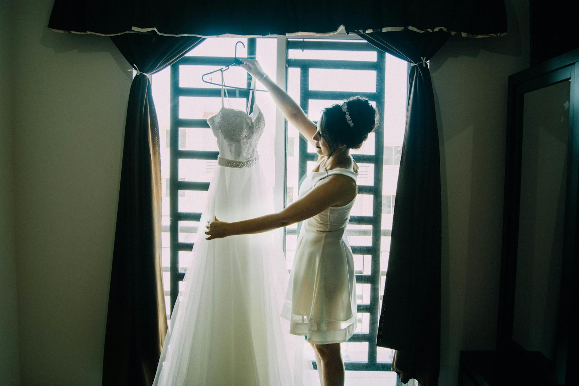 Elegant wedding dress hanging in preparation for destination wedding ceremony