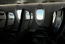 Modern airplane cabin interior showing premium economy seating with extra legroom and enhanced amenities