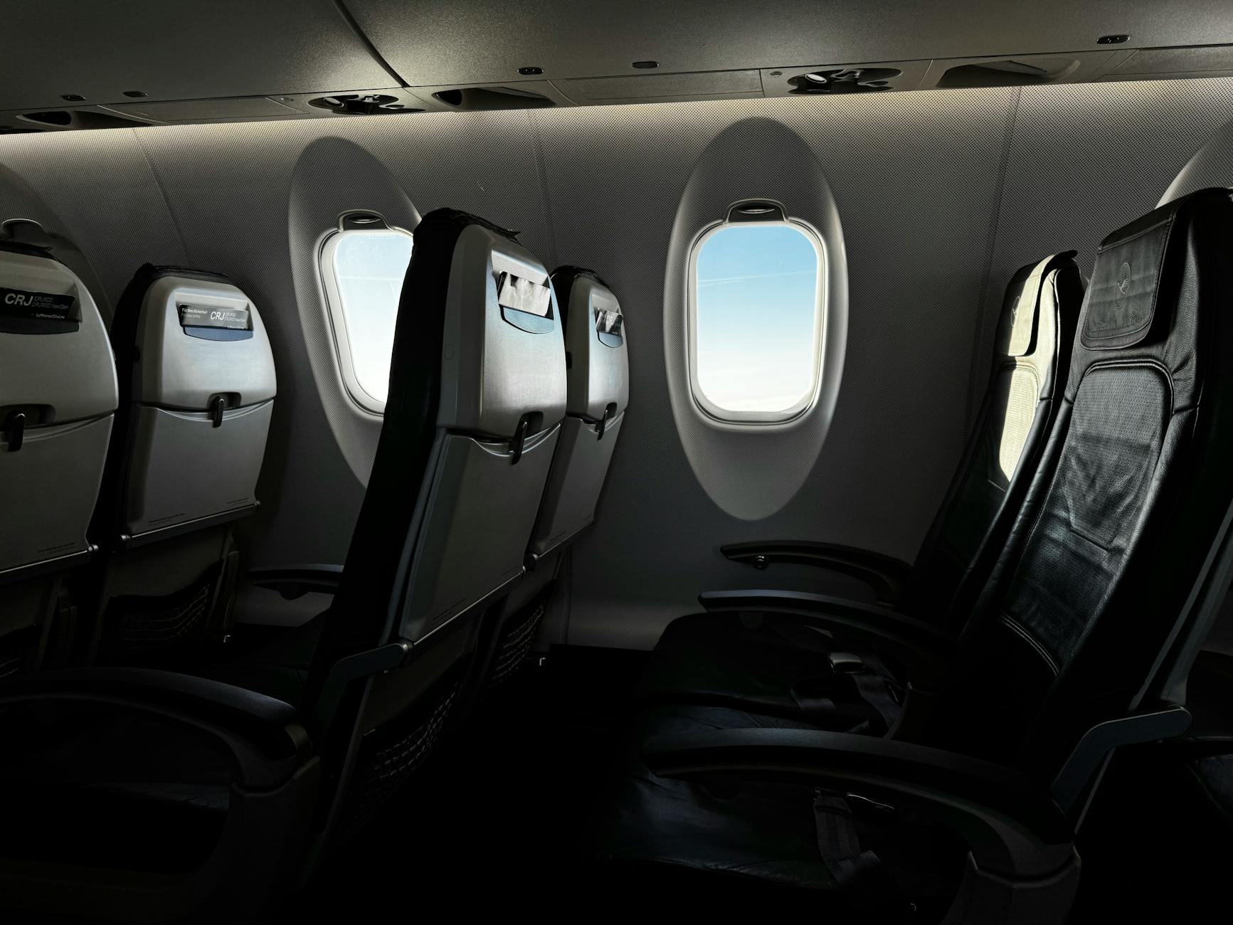 Modern airplane cabin interior showing premium economy seating with extra legroom and enhanced amenities