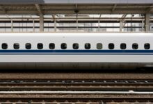 Modern Japanese bullet train traveling through snowy mountain landscape