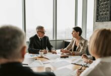 Professional meeting with people in business attire discussing around a conference table