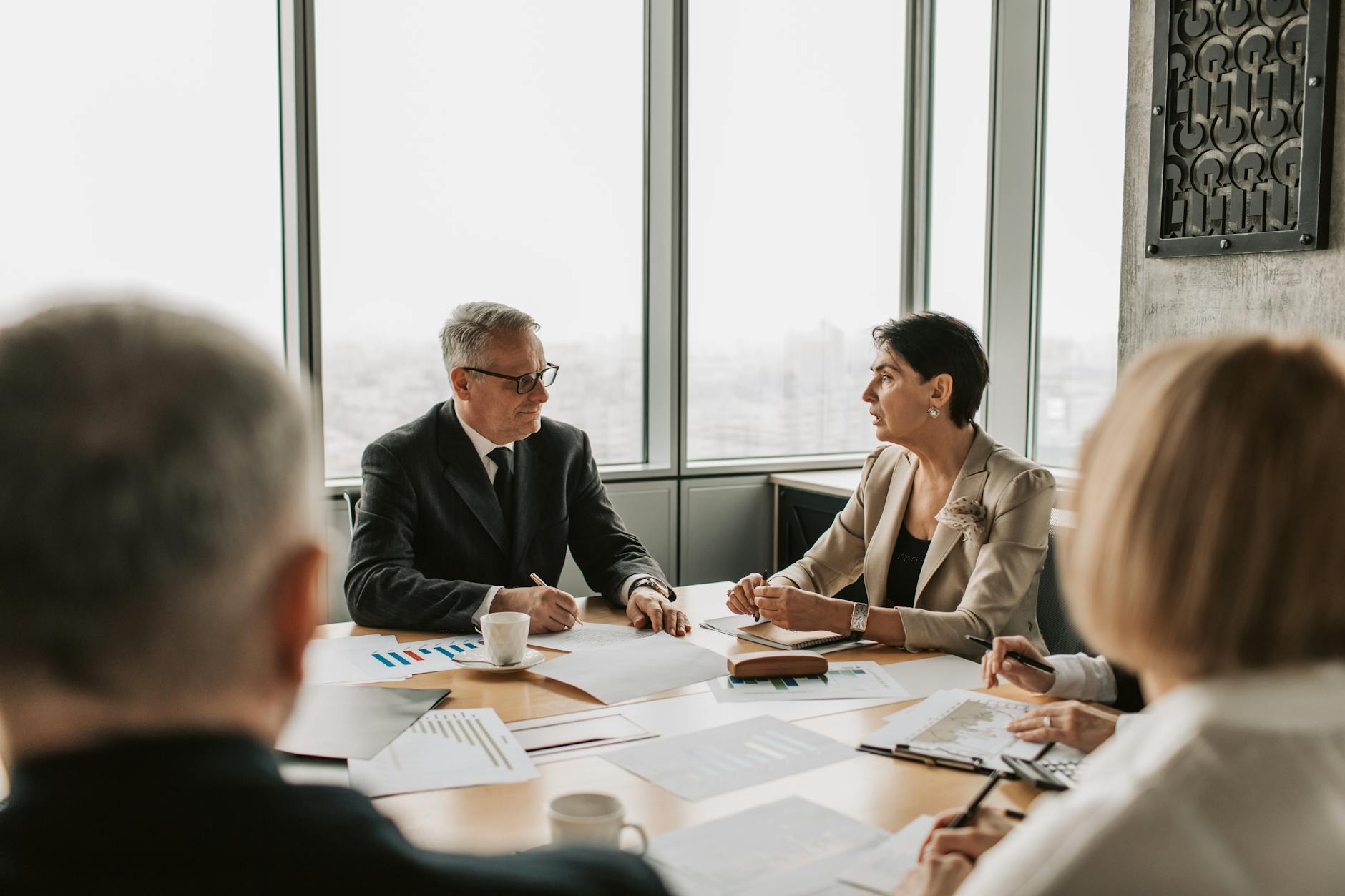 Professional meeting with people in business attire discussing around a conference table