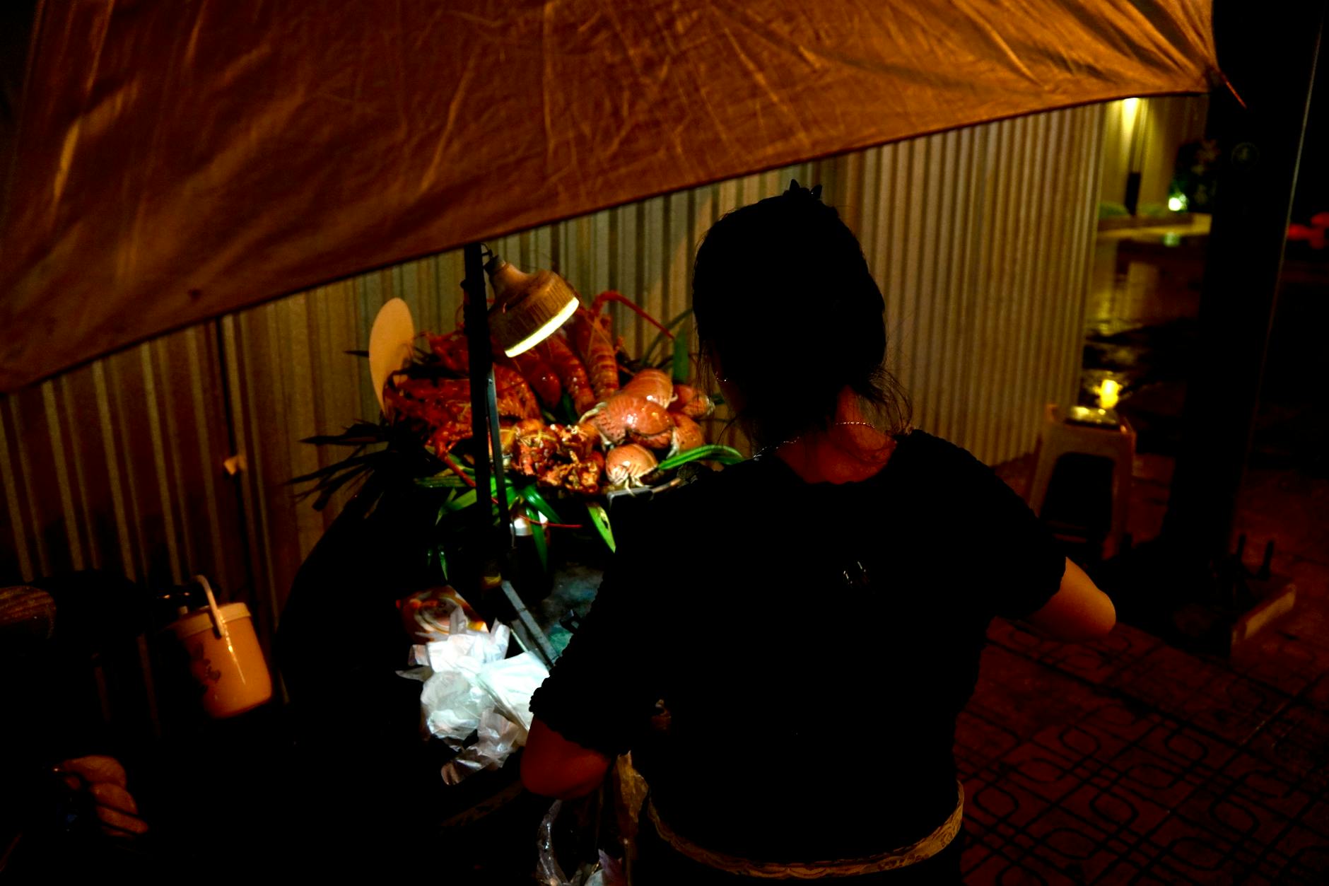 Local street food vendor preparing traditional dishes at outdoor market stall