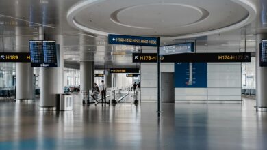 Modern airport lounge interior with comfortable seating, large windows, and travelers relaxing