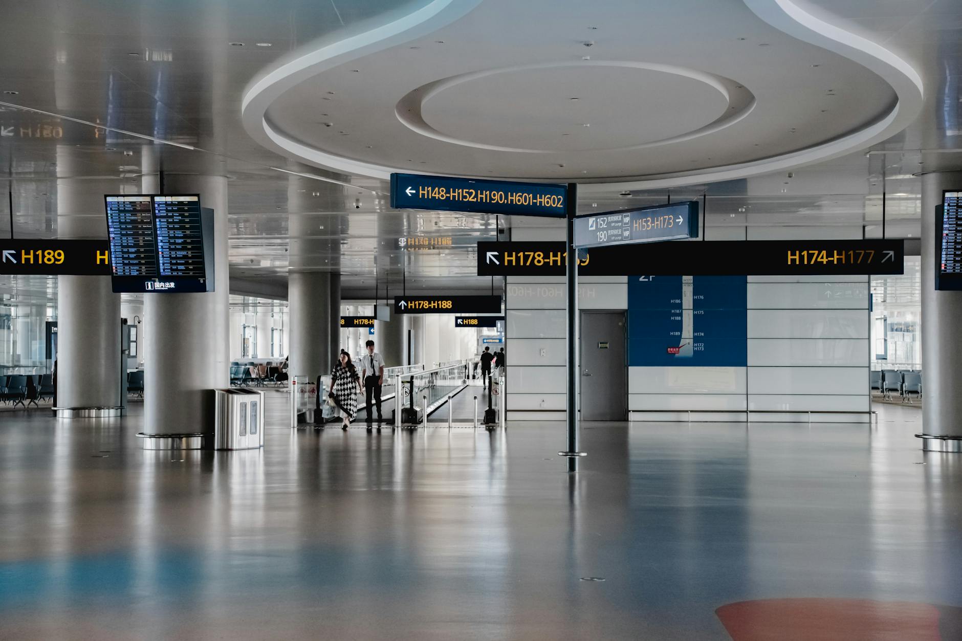 Modern airport lounge interior with comfortable seating, large windows, and travelers relaxing