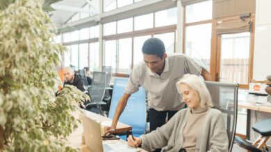 Modern co-working space with laptops and people working at shared tables