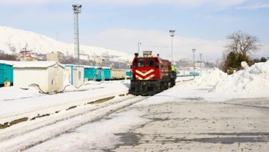 Train traveling through snowy Arctic landscape with snow-covered tracks and winter terrain