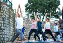 Corporate team practicing yoga together in an outdoor natural setting during a wellness retreat