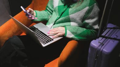 Electronics and travel accessories laid out next to open luggage for packing preparation