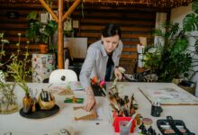 Modern creative workspace with art supplies and laptop showing community collaboration