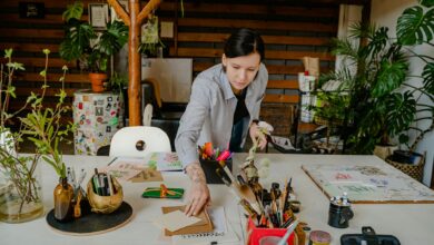 Modern creative workspace with art supplies and laptop showing community collaboration