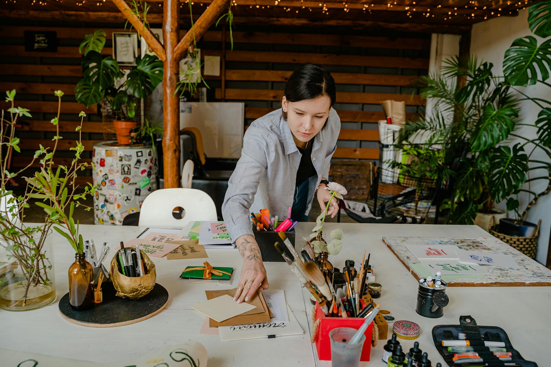 Modern creative workspace with art supplies and laptop showing community collaboration