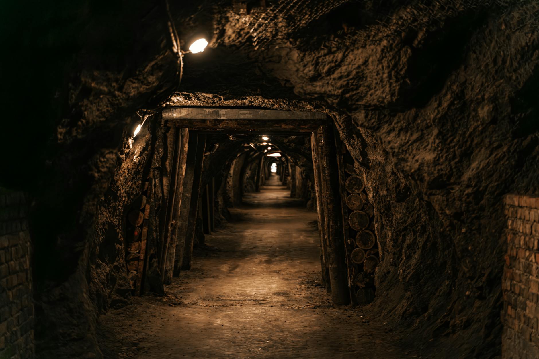 Ancient stone tunnel carved into rock with arched ceiling and narrow passageway