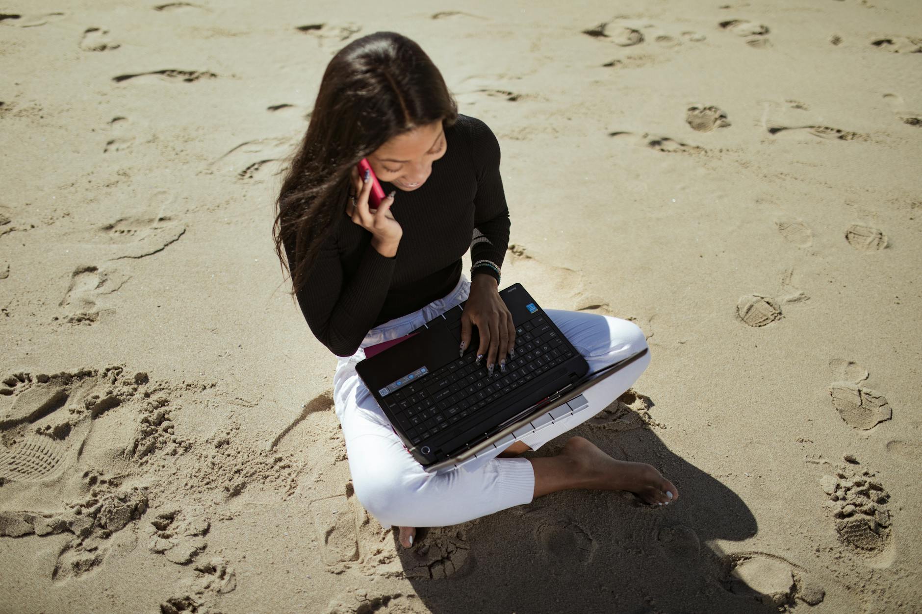 Person working on laptop at beachside cafe table