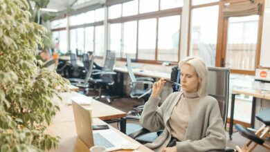 Professional woman in business attire practicing mindfulness in a modern office setting
