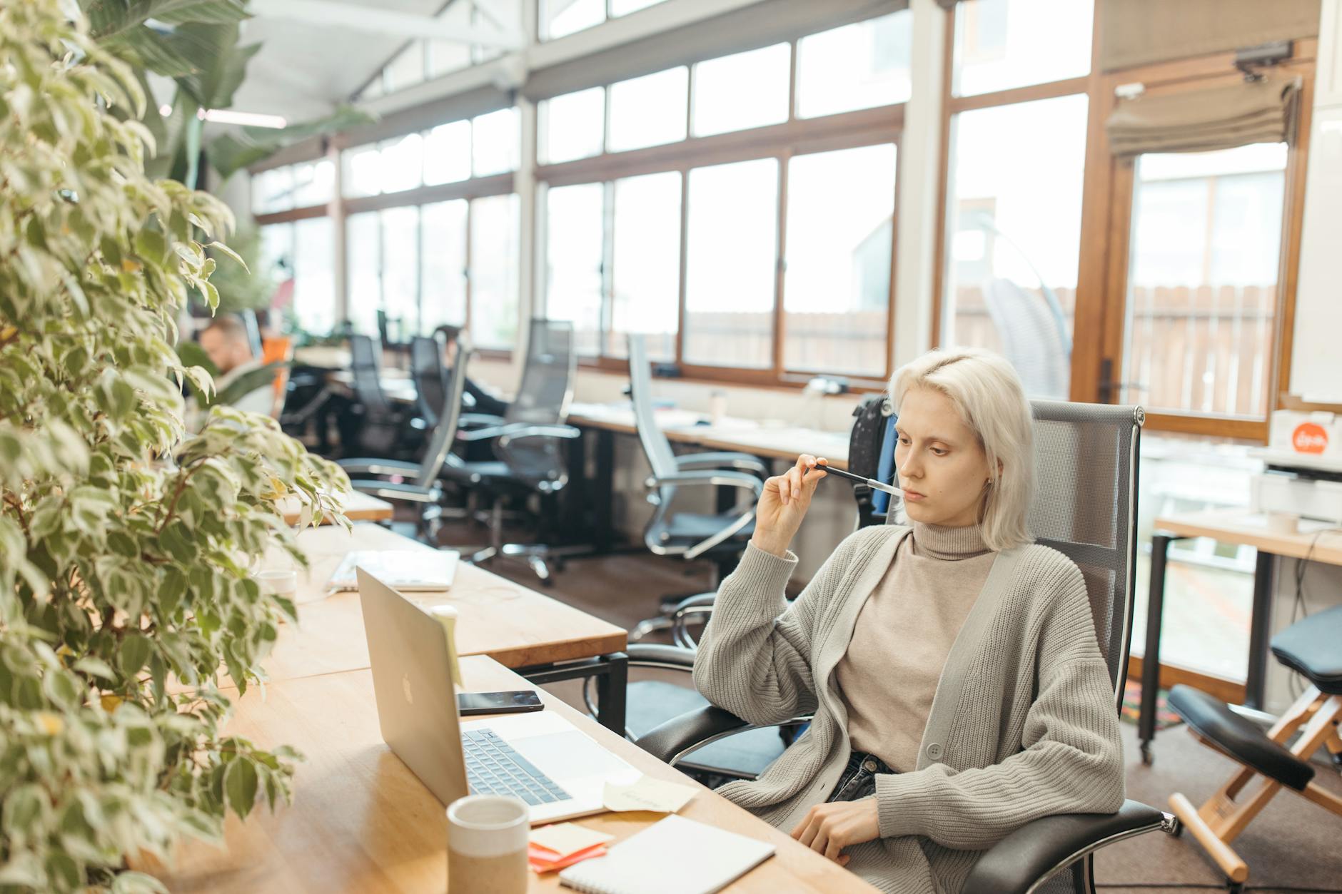 Professional woman in business attire practicing mindfulness in a modern office setting