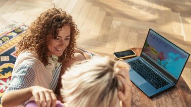 Group of friends sitting around table with maps and laptops planning their vacation together