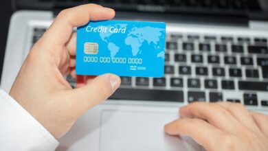 Credit cards next to laptop showing travel booking website for points optimization