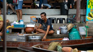 Traditional Vietnamese floating market with vendors selling fresh produce from wooden boats on river water