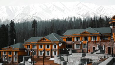 Snow-covered mountain lodge with traditional stone architecture against mountain peaks