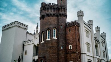 Medieval Gothic castle with pointed arches and stone towers against cloudy sky