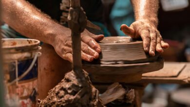 Hands shaping clay on a pottery wheel, representing analog craft activities