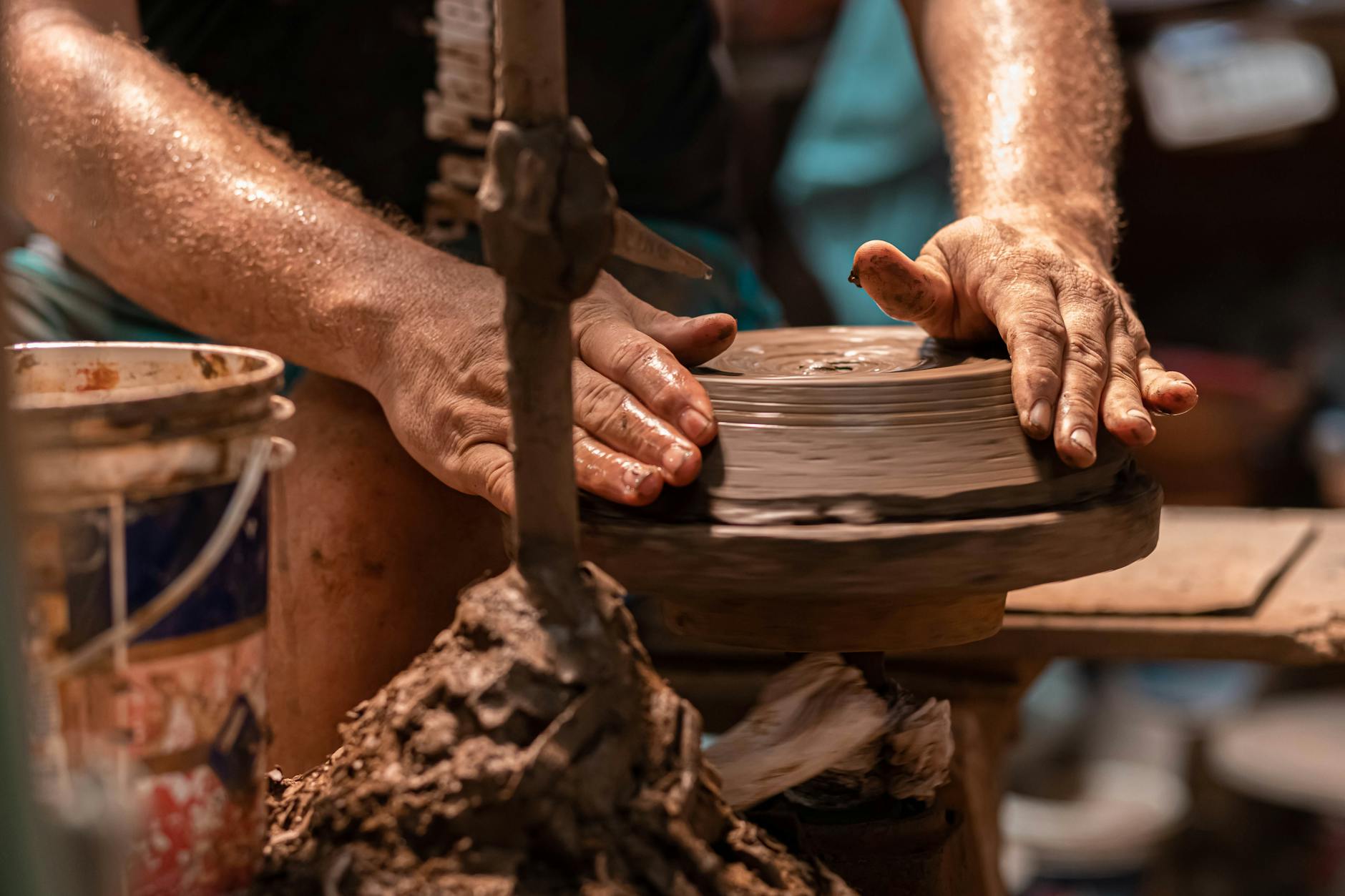 Hands shaping clay on a pottery wheel, representing analog craft activities