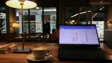 Person working on laptop in coffee shop with WiFi connection