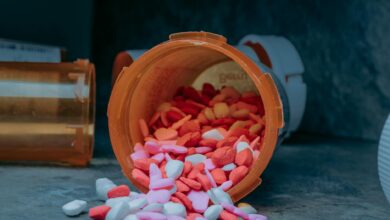 Multiple prescription medication bottles with pharmacy labels arranged on a table