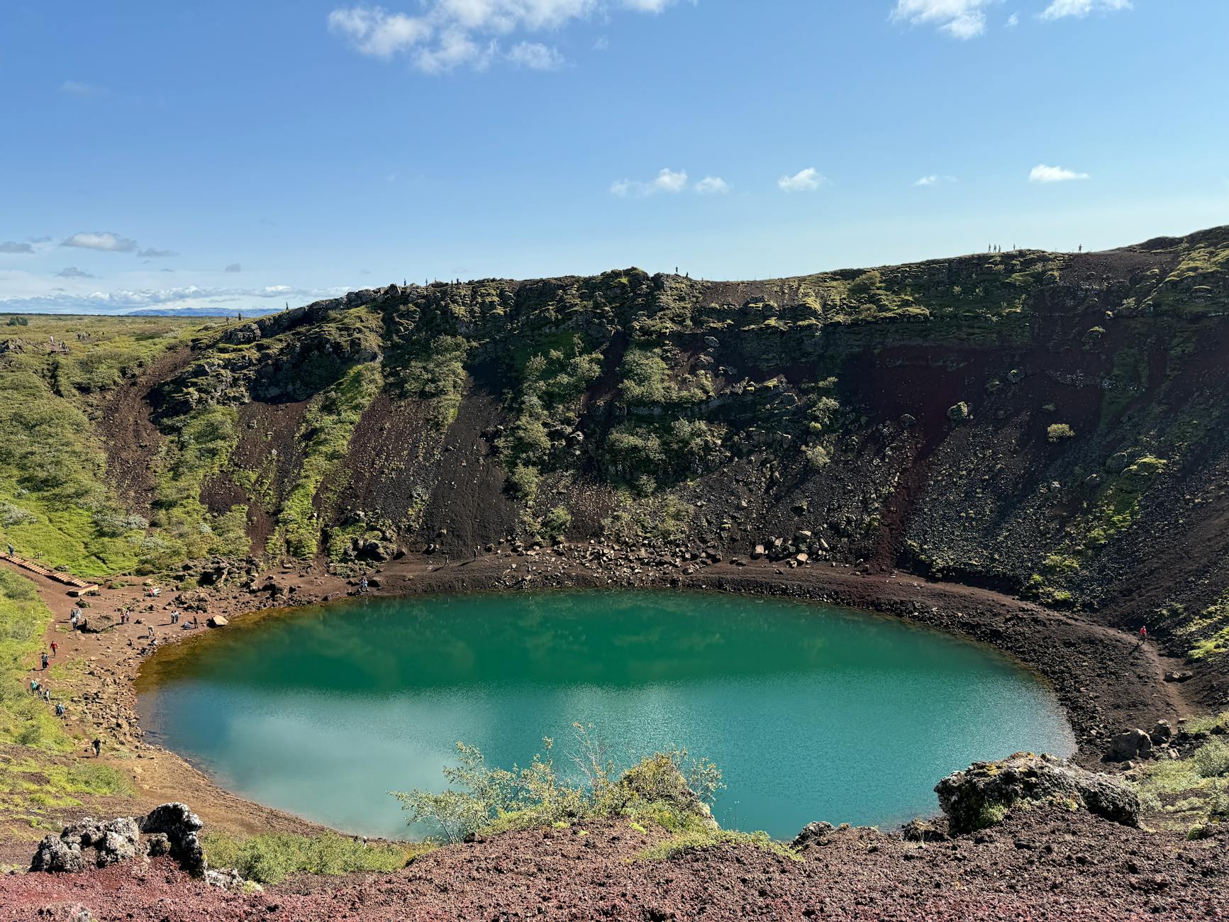 Hikers exploring volcanic crater rim with scenic lake views