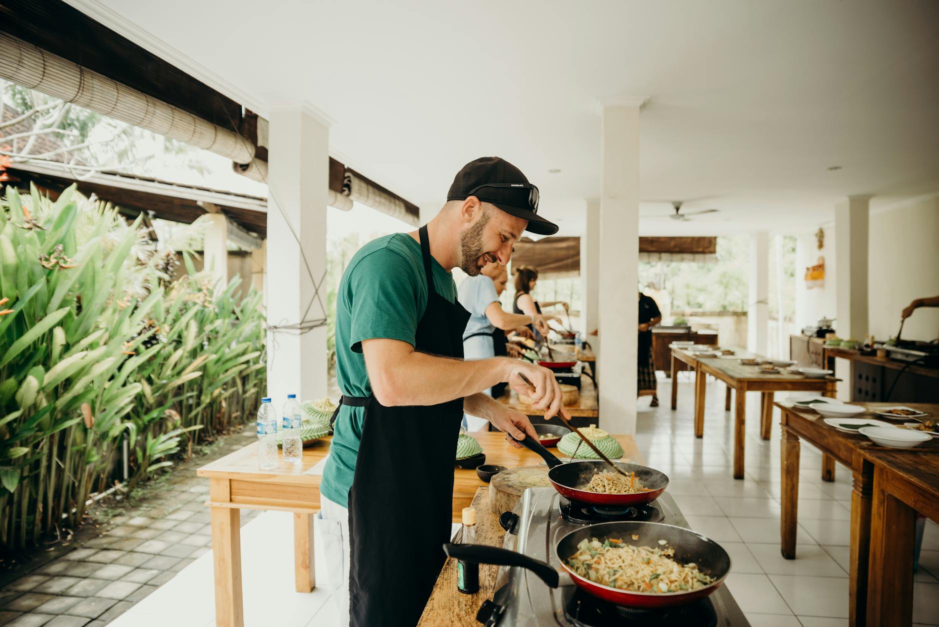Hands preparing food during outdoor cooking demonstration in rustic kitchen setting