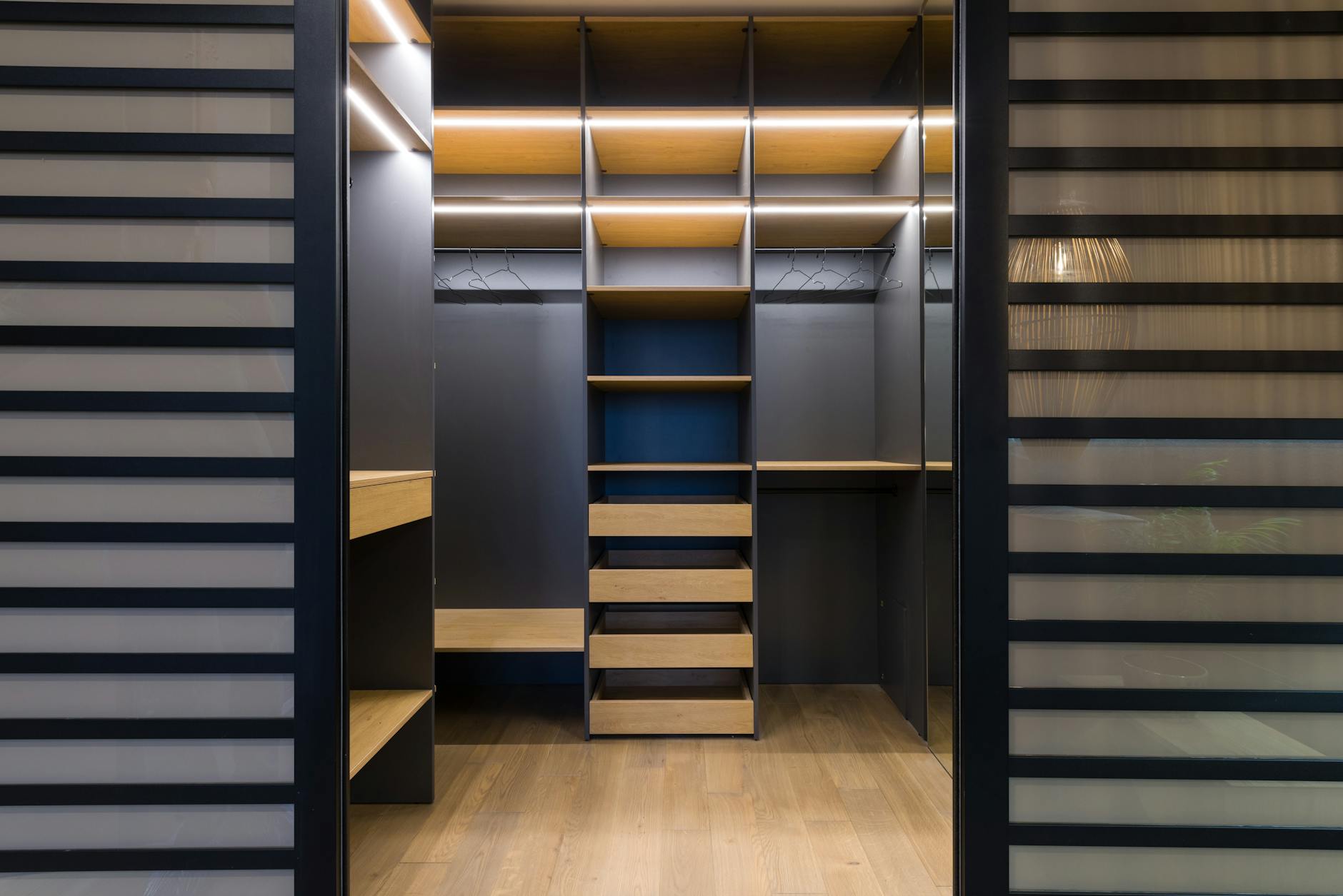 Professionally organized walk-in closet with systematic clothing arrangement and storage solutions