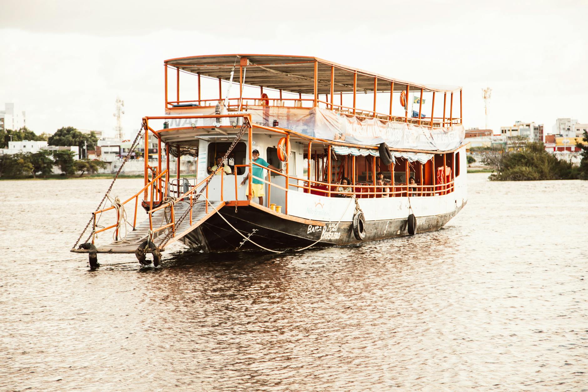 Chef teaching cooking techniques on boat with portable kitchen setup over water