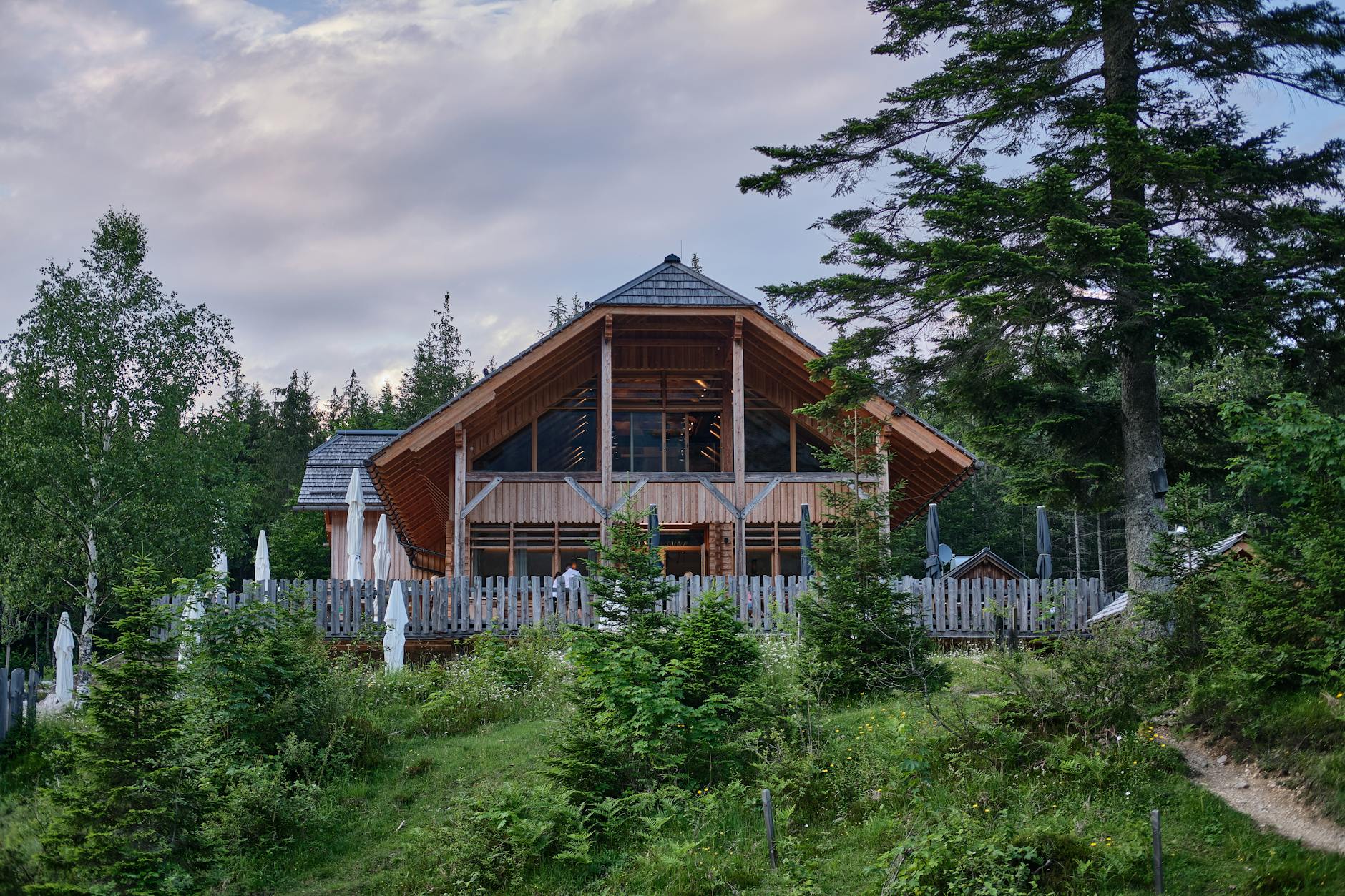 Traditional wooden lodge or guesthouse with carved details and mountain landscape setting
