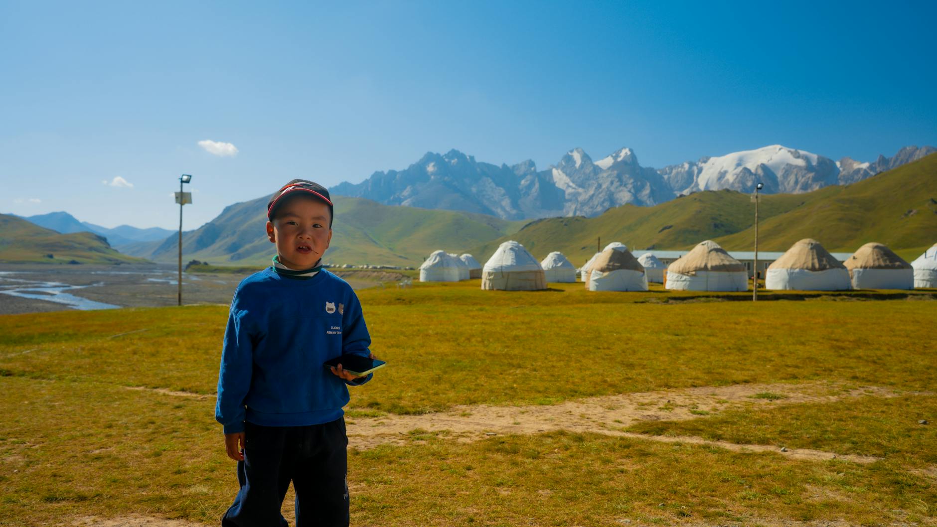 Traditional nomadic yurt dwelling set against expansive grassland under clear blue sky