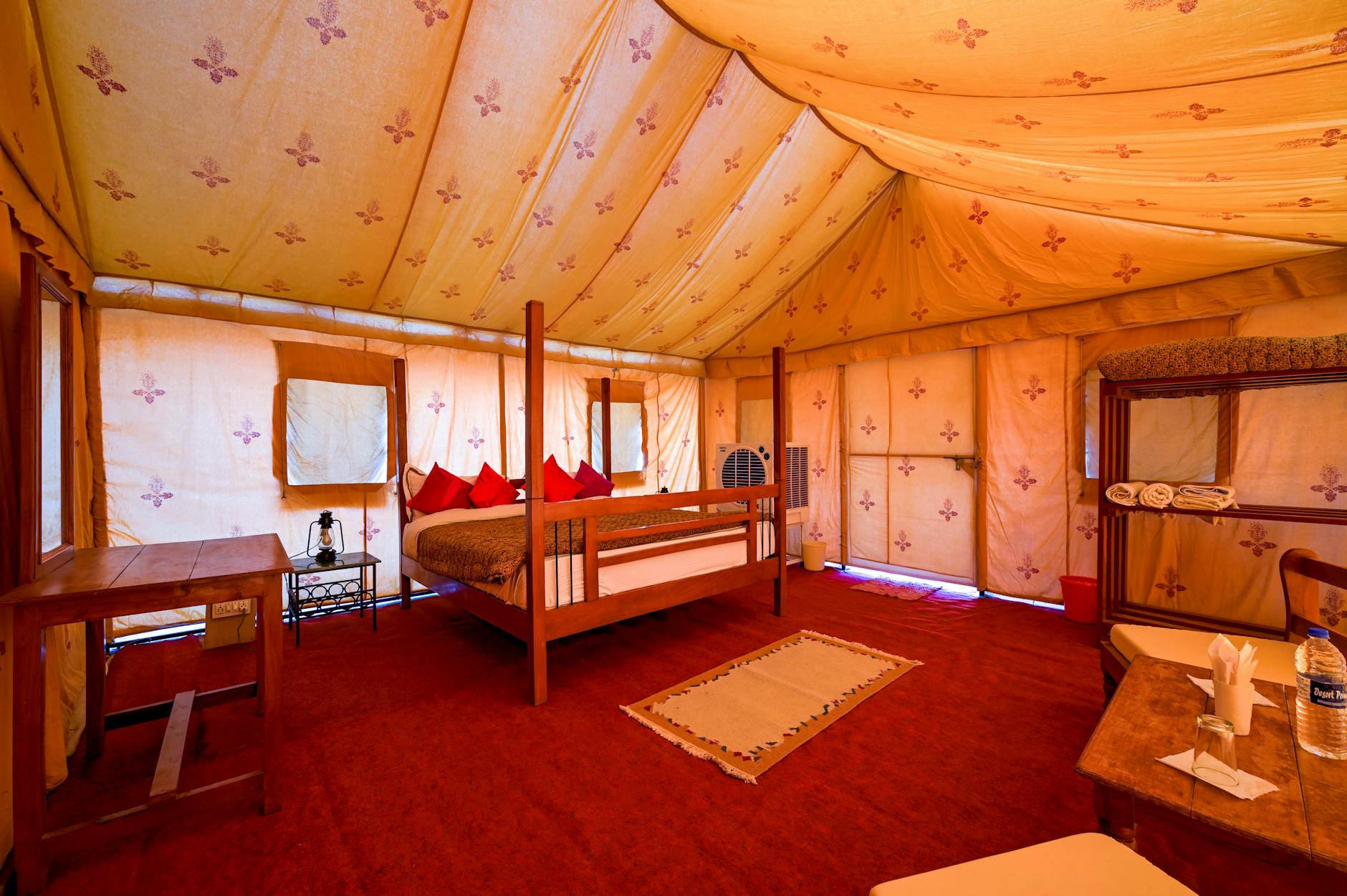 Spacious canvas safari tent with comfortable furnishings and viewing deck overlooking wilderness