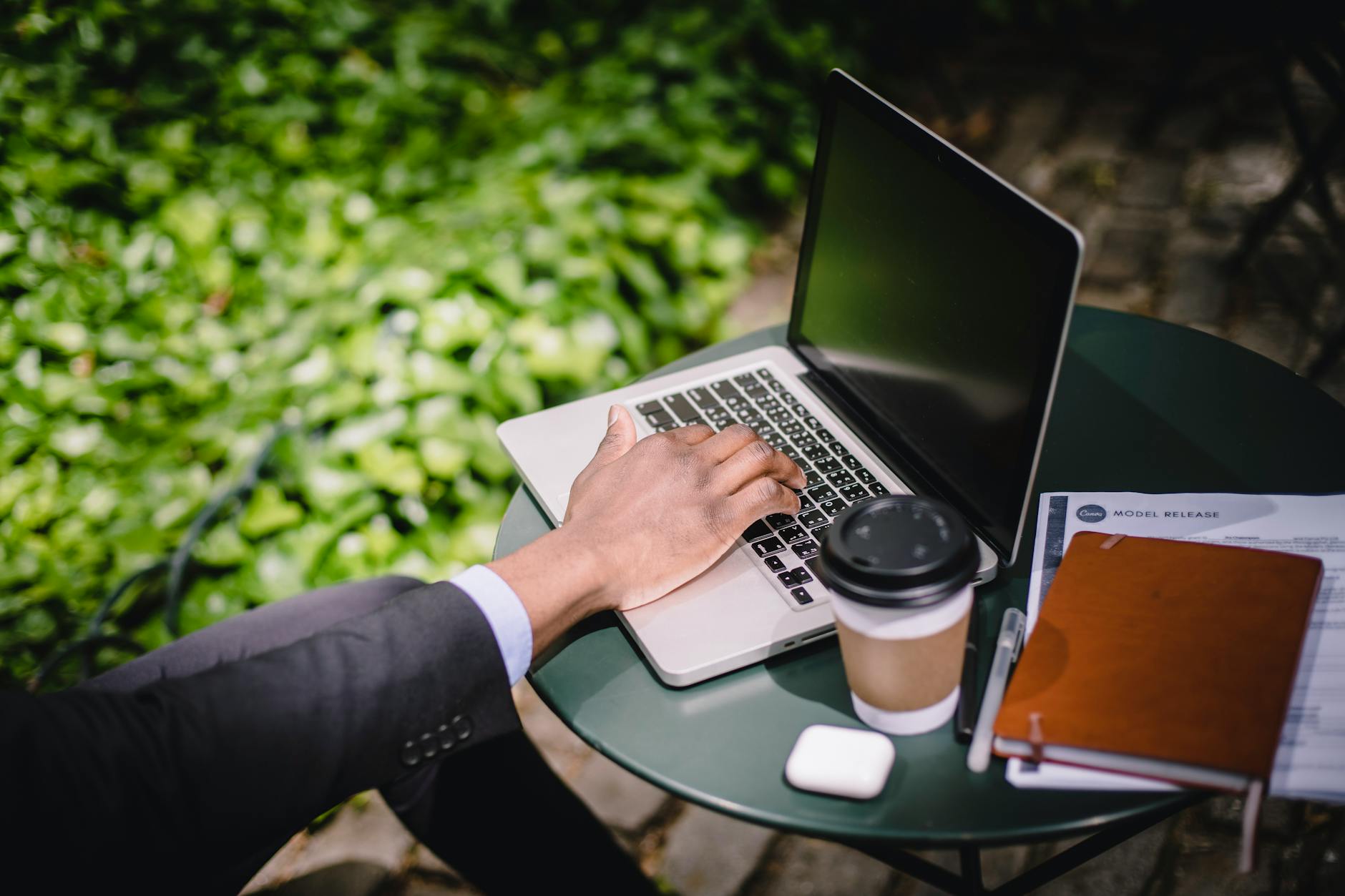 Person using laptop computer in airport cafe while connected to WiFi internet