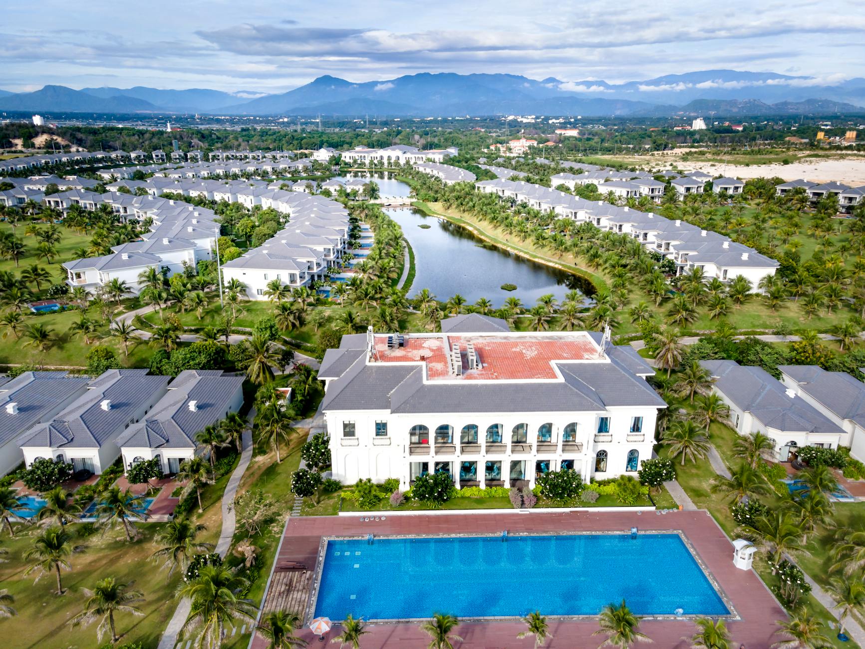 Upscale resort pool area with palm trees and ocean view